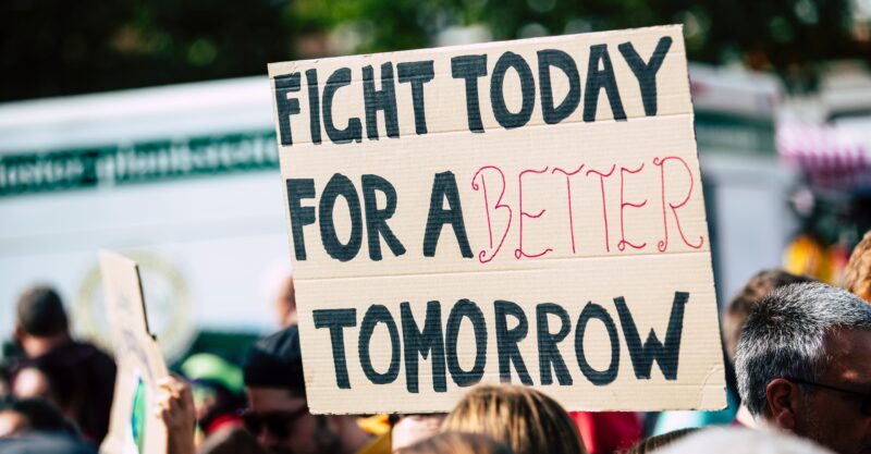 cardboard sign that says fight today for a better tomorrow